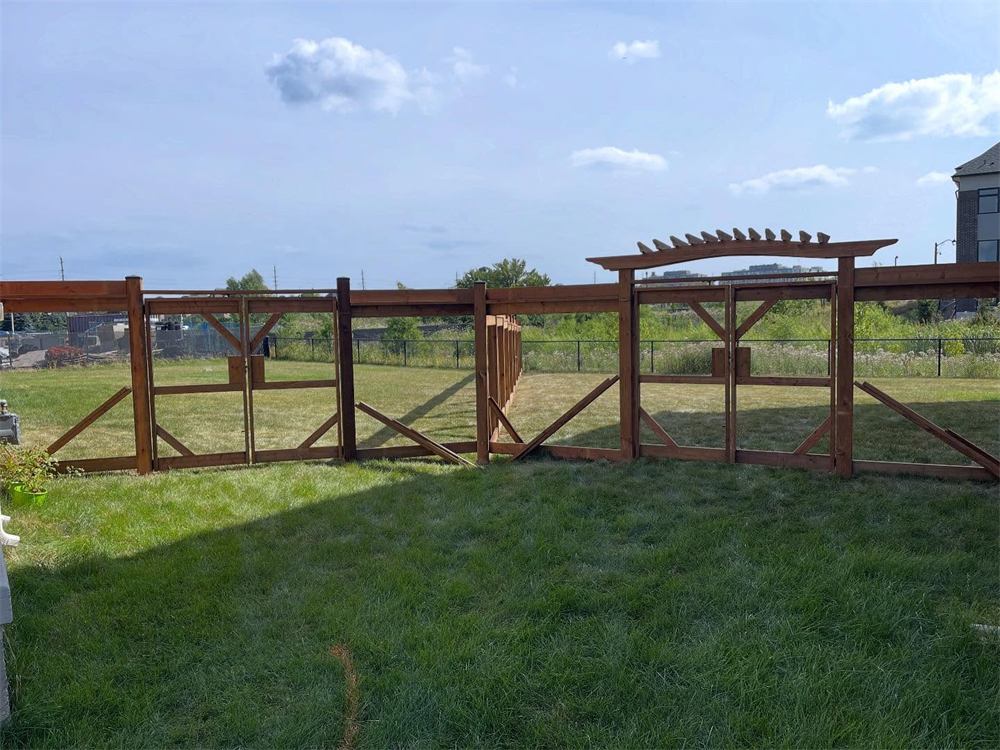 Long backyard fence with a cedar arbour over the gate
