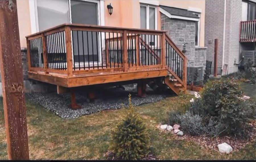 Wood deck with black metal railings and stairs