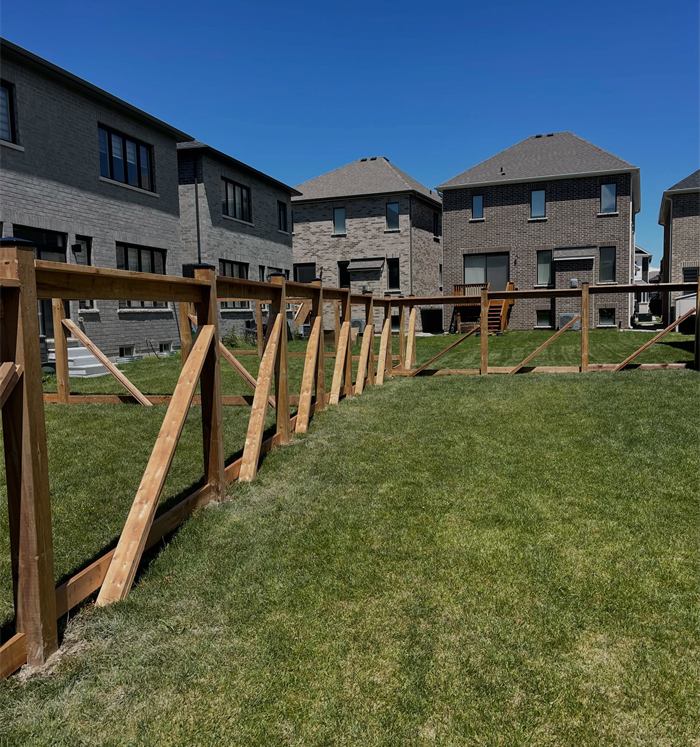 New fence frame with rails across a backyard